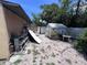 View of a backyard with sheds, patio furniture, and a white fence. The yard is mostly sand with some grass at 4104 W North B St, Tampa, FL 33609