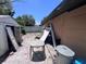 Overgrown backyard with a shed and building debris, including a table, trash can, and discarded doors at 4104 W North B St, Tampa, FL 33609