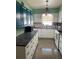 Bright kitchen features white cabinets, black countertops, and modern light fixture at 4104 W North B St, Tampa, FL 33609