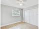 Bright bedroom with wood-look floors, ceiling fan, window, and double-door closet at 416 Flamingo Dr, Apollo Beach, FL 33572