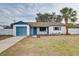 Charming single-story home with a well-maintained lawn and a quaint blue-accented garage at 416 Flamingo Dr, Apollo Beach, FL 33572