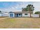 Charming home with a blue garage door, blue accents, and a well-maintained lawn at 416 Flamingo Dr, Apollo Beach, FL 33572
