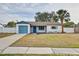Charming home with a blue garage door, blue accents, and a well-maintained lawn at 416 Flamingo Dr, Apollo Beach, FL 33572