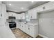 Modern kitchen with stainless steel appliances, white cabinetry, and a herringbone backsplash at 416 Flamingo Dr, Apollo Beach, FL 33572