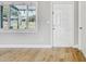 Living area with hardwood flooring, a white door, and a bright window at 416 Flamingo Dr, Apollo Beach, FL 33572
