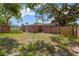 A spacious backyard with mature trees, a brick home, and a storage shed at 4512 24Th Ave S, Tampa, FL 33619