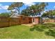 Backyard with a wooden fence, a deck, and mature trees at 4512 24Th Ave S, Tampa, FL 33619