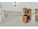 Open-concept living room and kitchen feature tile flooring, stainless steel appliances, and warm wood cabinetry at 4512 24Th Ave S, Tampa, FL 33619