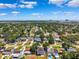 Community aerial shot showcasing neighborhood homes and lush trees under blue skies at 4717 W Lawn Ave, Tampa, FL 33611