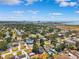Wide aerial shot of a neighborhood featuring single Gathering homes, blue skies, and water in the distance at 4717 W Lawn Ave, Tampa, FL 33611