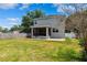 Two-story home with a screened in porch and backyard featuring well-maintained lawn at 4717 W Lawn Ave, Tampa, FL 33611