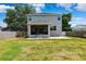 Home's back exterior with screened-in porch and well-maintained lawn at 4717 W Lawn Ave, Tampa, FL 33611