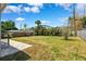Large, grassy backyard surrounded by a wooden fence and lush greenery, perfect for outdoor activities at 4717 W Lawn Ave, Tampa, FL 33611