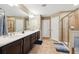 Bright bathroom features a double vanity with dark cabinets, tiled floor, and glass door shower at 4717 W Lawn Ave, Tampa, FL 33611