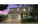 Charming two-story home featuring a two-car garage, landscaped yard, and covered entryway with arched columns at 4717 W Lawn Ave, Tampa, FL 33611