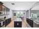Spacious kitchen featuring granite countertops, dark cabinetry, a center island, and a bright, airy breakfast nook at 4717 W Lawn Ave, Tampa, FL 33611