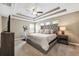 Warm and inviting main bedroom features a tray ceiling, ceiling fan, and neutral tones at 4717 W Lawn Ave, Tampa, FL 33611