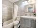 Bathroom featuring tub and shower combination with gray tiled walls and a modern vanity at 5153 Miller Bayou Dr, Port Richey, FL 34668