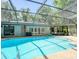 Sparkling pool with an enclosure, surrounded by ample seating, offering a perfect relaxation space at 5153 Miller Bayou Dr, Port Richey, FL 34668
