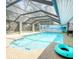 Large enclosed in-ground pool with a beach themed mural on an adjacent wall at 5153 Miller Bayou Dr, Port Richey, FL 34668