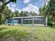 A screened pool enclosure surrounded by lush landscaping providing a private outdoor retreat at 5153 Miller Bayou Dr, Port Richey, FL 34668