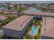 Aerial view showcases condos with the shared community pool and a serene waterfront backdrop at 521 Pinellas Bayway S # 301, St Petersburg, FL 33715