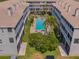 Aerial view displays a community pool, surrounded by lush landscaping between condo buildings at 521 Pinellas Bayway S # 301, St Petersburg, FL 33715