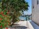 Cozy backyard scene with lush greenery, a glimpse of a canal, and a boat lift, perfect for waterfront living at 521 Pinellas Bayway S # 301, St Petersburg, FL 33715