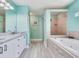 Bright bathroom with a jacuzzi bathtub, stand-up shower, double vanity, and modern fixtures at 521 Pinellas Bayway S # 301, St Petersburg, FL 33715