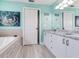 Bright bathroom with a jacuzzi bathtub, a double vanity with granite countertop, and modern fixtures at 521 Pinellas Bayway S # 301, St Petersburg, FL 33715