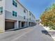 Long view of townhomes with multiple garages and a nicely landscaped area, all under a bright blue sky at 521 Pinellas Bayway S # 301, St Petersburg, FL 33715