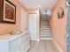 Inviting foyer with staircase, white dresser, and beachy decor at 521 Pinellas Bayway S # 301, St Petersburg, FL 33715
