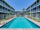 Community pool surrounded by condos offers a refreshing escape with clear blue water on a sunny day at 521 Pinellas Bayway S # 301, St Petersburg, FL 33715