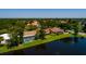 Aerial view showcasing a home with a screened pool, lush landscaping, and water views at 5242 Venice Ne Way, St Petersburg, FL 33703