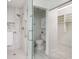 Modern bathroom with glass shower, neutral tiles, and closet access at 5242 Venice Ne Way, St Petersburg, FL 33703