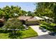Charming single-story home features a tile roof, mature trees, and a well-manicured lawn at 5242 Venice Ne Way, St Petersburg, FL 33703
