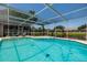 Relaxing view of the screened in-ground pool overlooking a pond and neighborhood homes at 5242 Venice Ne Way, St Petersburg, FL 33703