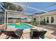 Enjoy the in-ground pool, screened for outdoor relaxation, featuring an outdoor dining area and lounge chairs at 5242 Venice Ne Way, St Petersburg, FL 33703