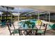 Relaxing screened lanai with a table set for four, view of the pool and a view of the water at 5242 Venice Ne Way, St Petersburg, FL 33703