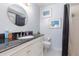 Bathroom featuring a round mirror, black countertop, vanity, and tub-shower combo with a black shower curtain at 5666 Gardens Dr # 202, Sarasota, FL 34243