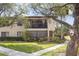 Charming condo building with a well-manicured lawn, mature tree and inviting entrance at 5666 Gardens Dr # 202, Sarasota, FL 34243