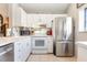 Kitchen with stainless steel appliances, white cabinets, and neutral countertops at 5666 Gardens Dr # 202, Sarasota, FL 34243