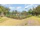 Community tennis court surrounded by lush greenery and fencing for an active lifestyle at 5666 Gardens Dr # 202, Sarasota, FL 34243