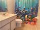 Bathroom featuring a vanity with a sink and toilet next to a shower with a colorful dolphin-themed curtain at 5970 80Th N St # 204, St Petersburg, FL 33709