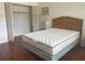 Bedroom with wood floors, a bed with a white mattress, and a closet with folding doors at 5970 80Th N St # 204, St Petersburg, FL 33709
