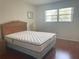 Bedroom with wood floors, a queen bed, a nightstand, and a window with natural light at 5970 80Th N St # 204, St Petersburg, FL 33709