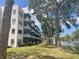 Exterior view of a white condo building with screened-in balconies overlooking a lake at 5970 80Th N St # 204, St Petersburg, FL 33709
