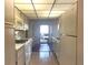 Bright kitchen with white appliances, cabinetry, and a view to an outdoor balcony at 5970 80Th N St # 204, St Petersburg, FL 33709
