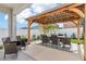 Picturesque backyard showcasing an inviting outdoor dining area beneath a charming wooden pergola at 6398 Bar S Bar Trl, Zephyrhills, FL 33541
