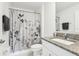 Cozy bathroom with gray floral curtain, granite counter tops, and neutral colors at 6398 Bar S Bar Trl, Zephyrhills, FL 33541